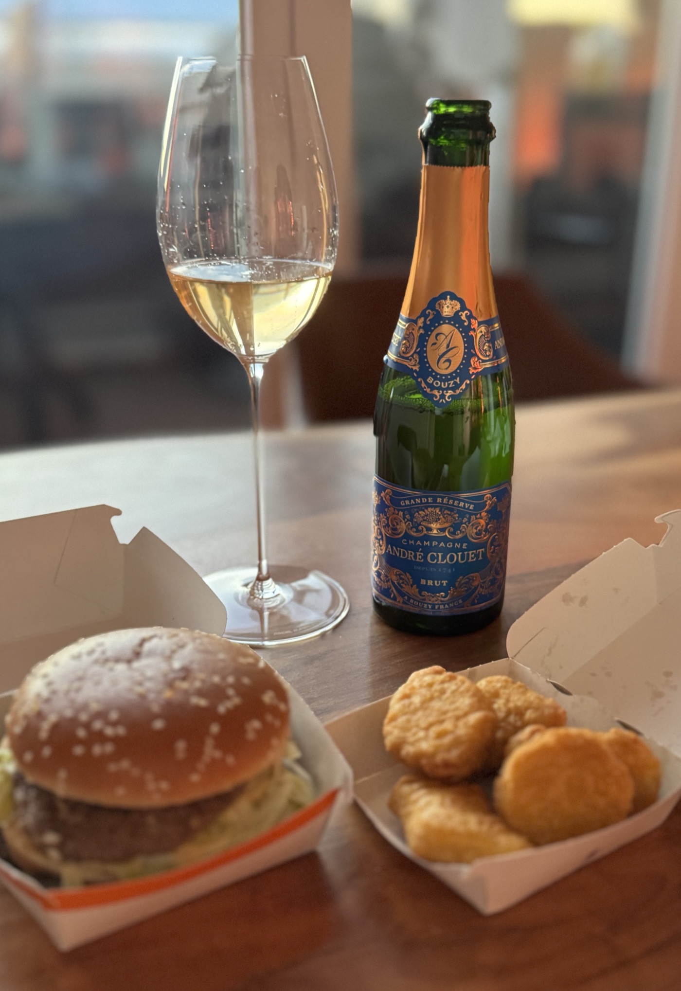 Champagne Andr&eacute; Clouet Grande R&eacute;serve Bouzy 375 mL in a Riedel Champagne glass, paired with a Big Mac and chicken nuggets