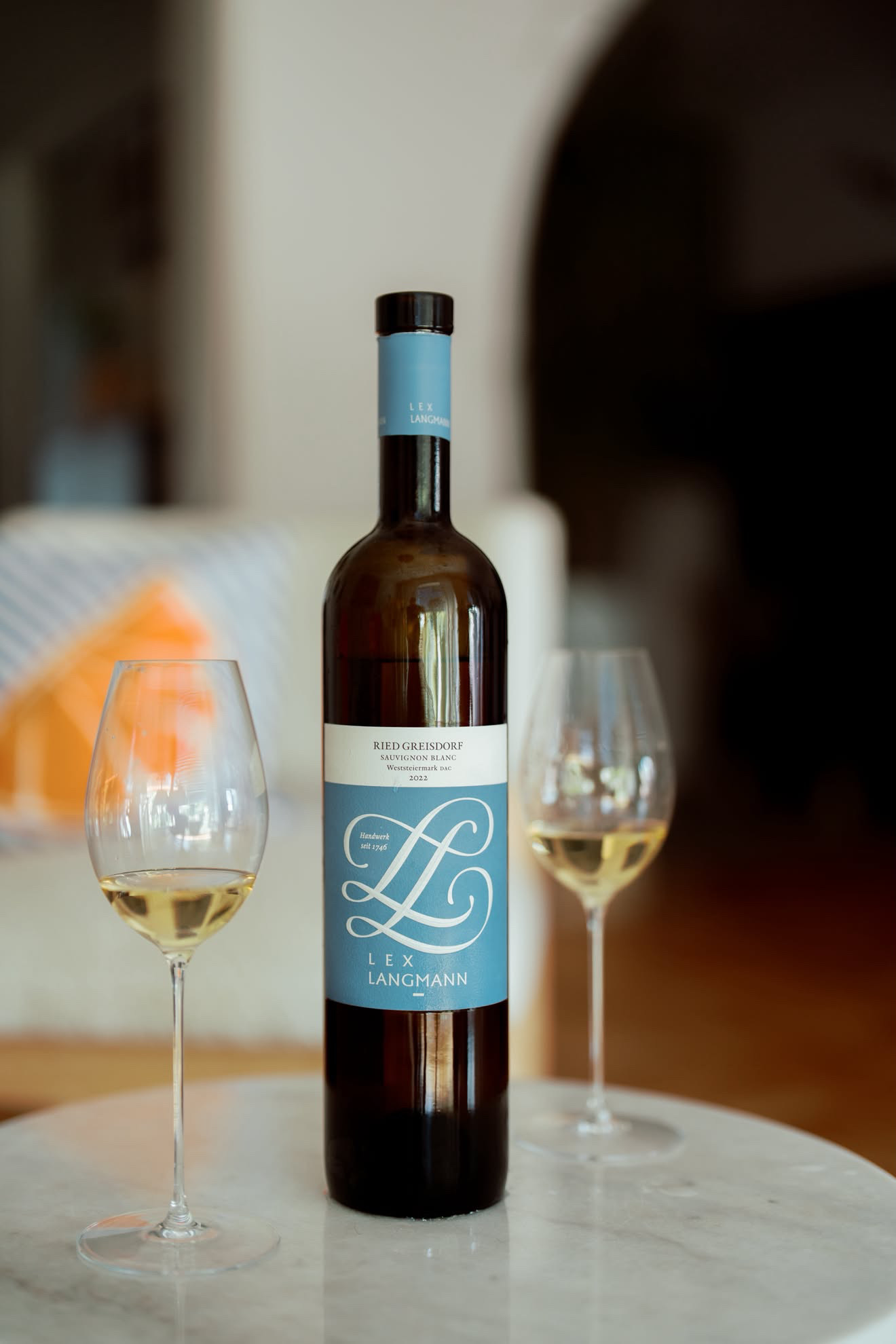 Lex Langmann Ried Greisdorf Sauvignon Blanc Weststeiermark DAC 2022 between two Riedel Superleggero Sauvignon Blanc glasses on a marble table