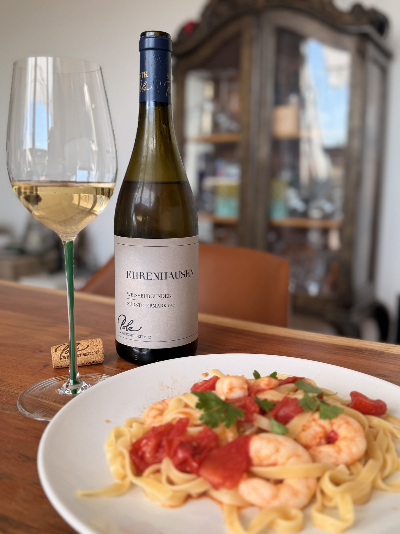 Polz Ried Ehrenhausen Weissburgunder 2024 in a Riedel Fatto a Mano glass with Murano glass style stem, next to a plate of tagliatelle with prawns and tomato