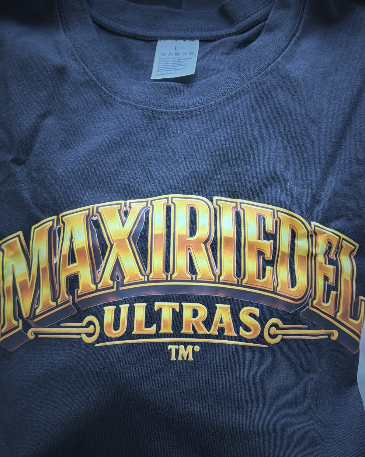 Black T-shirt with MAXIRIEDEL in perspective chrome blockbuster type